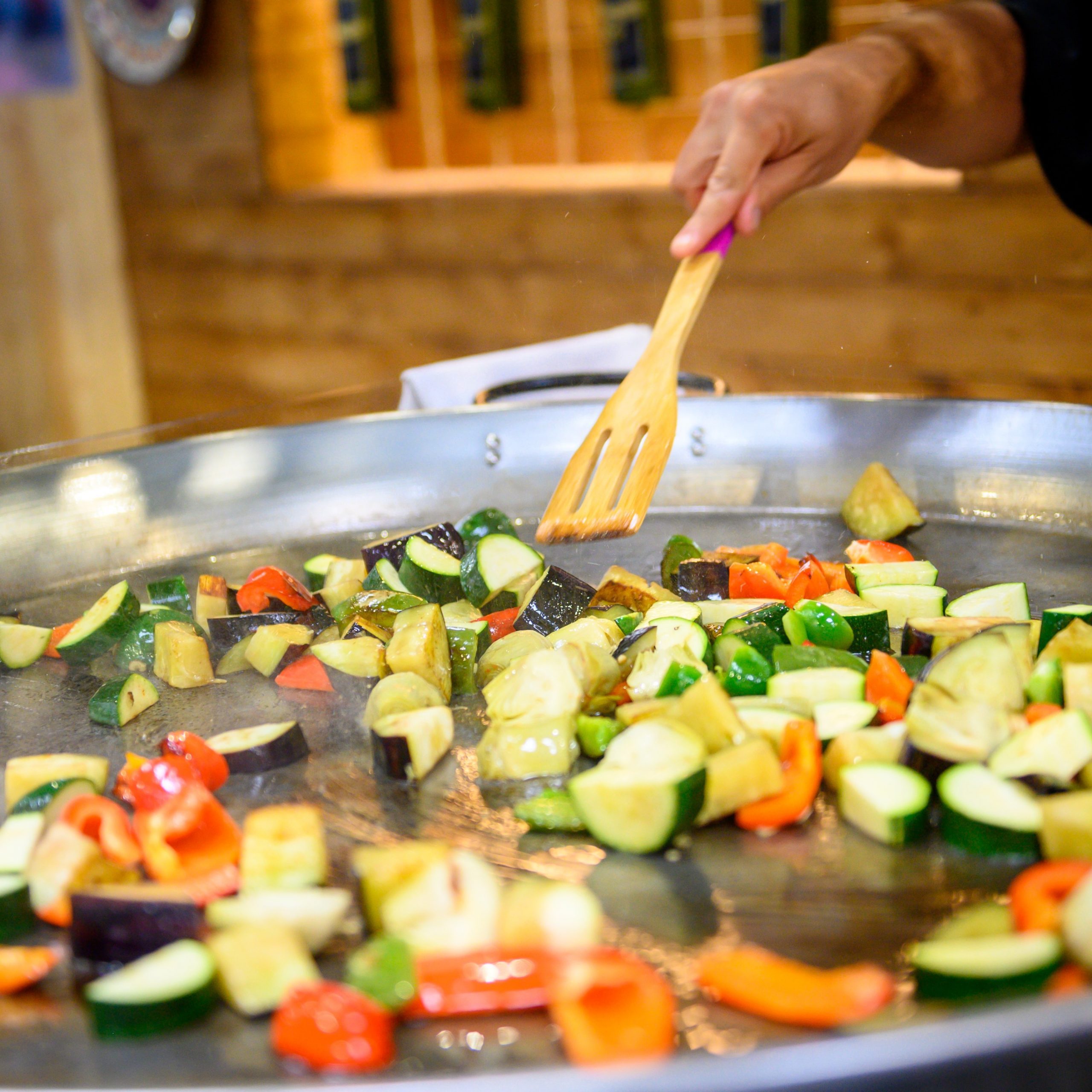 Large pan in which courgettes, tomatoes and more are shallow-fried